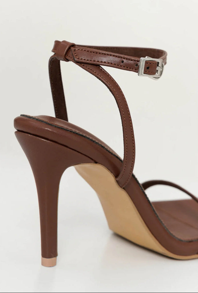 dark Brown high-heeled sandal with a strap on a background
