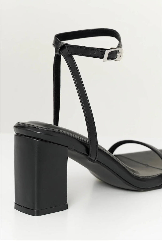 Black sandal with a block heel on a background