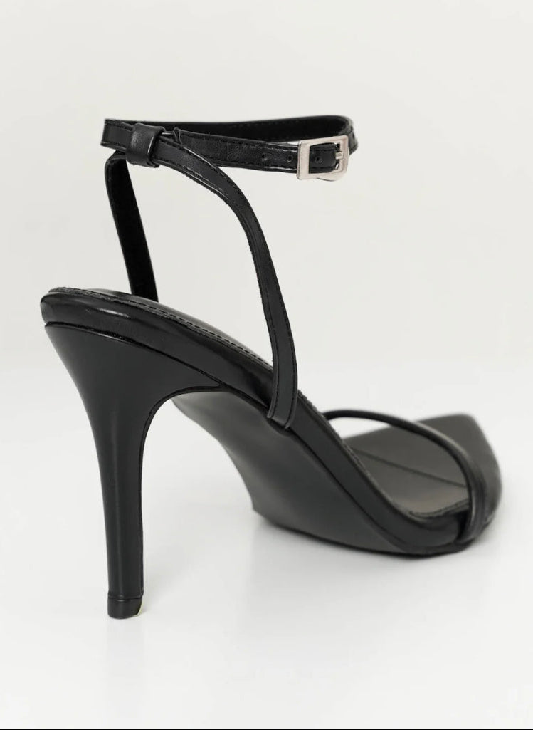 Black high-heeled sandal on a background