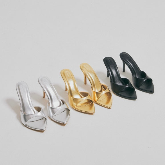 Four pairs of high-heeled shoes in silver, (7 cm), silver (9 cm), gold (9 cm), and black (9 cm) on a light gray background