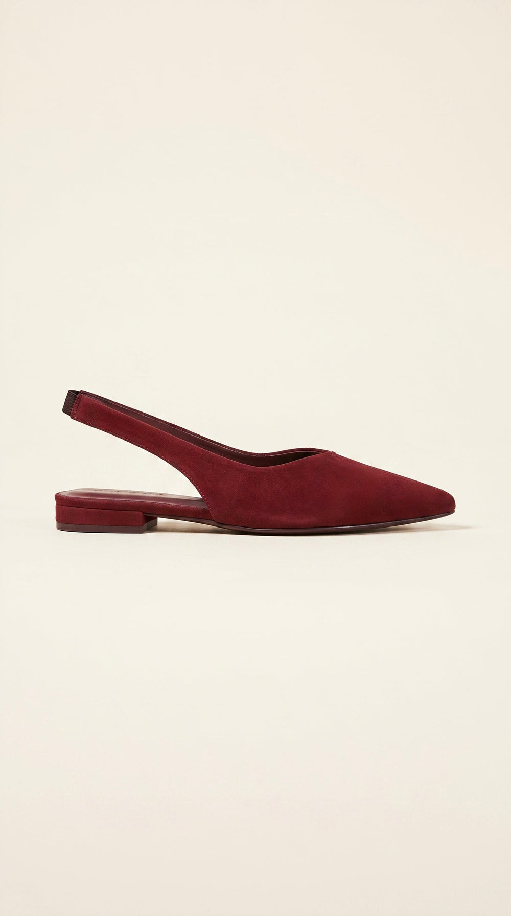 Maroon suede slingback flat shoe on a light beige background