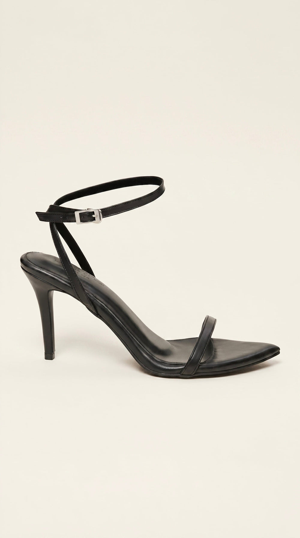 Black high-heeled sandal on a beige background
