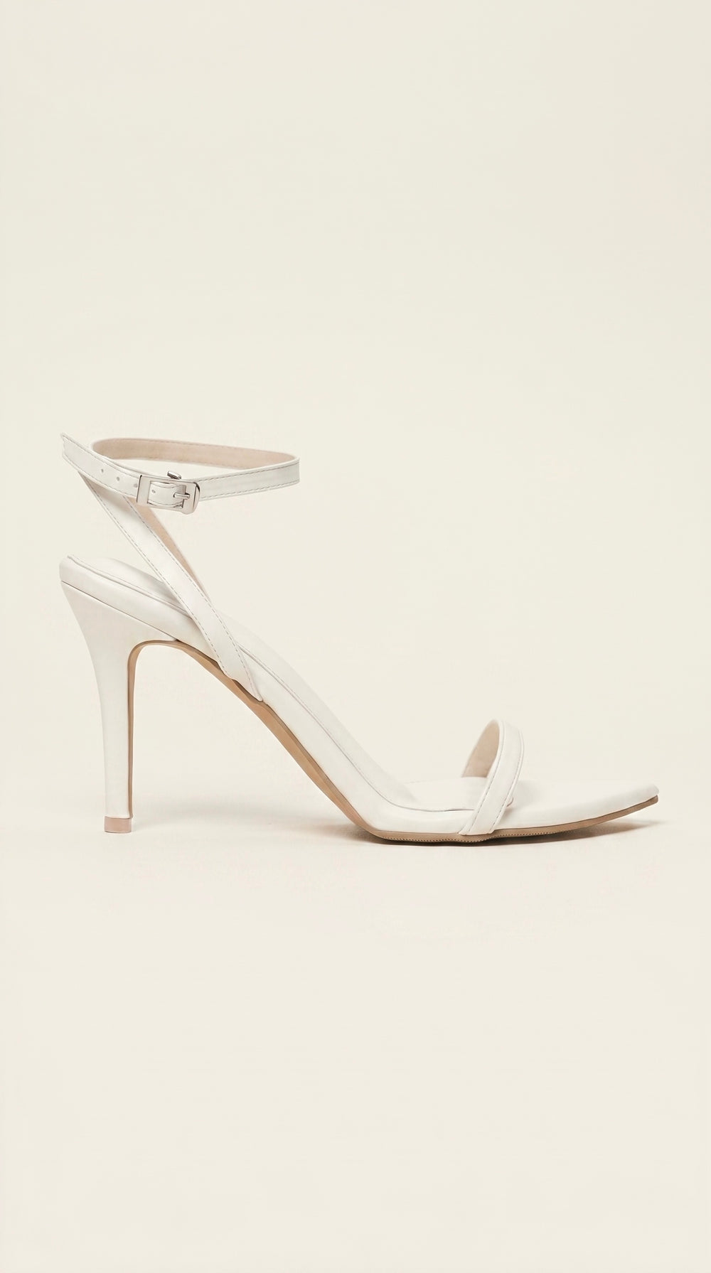White high-heeled sandal on a light beige background