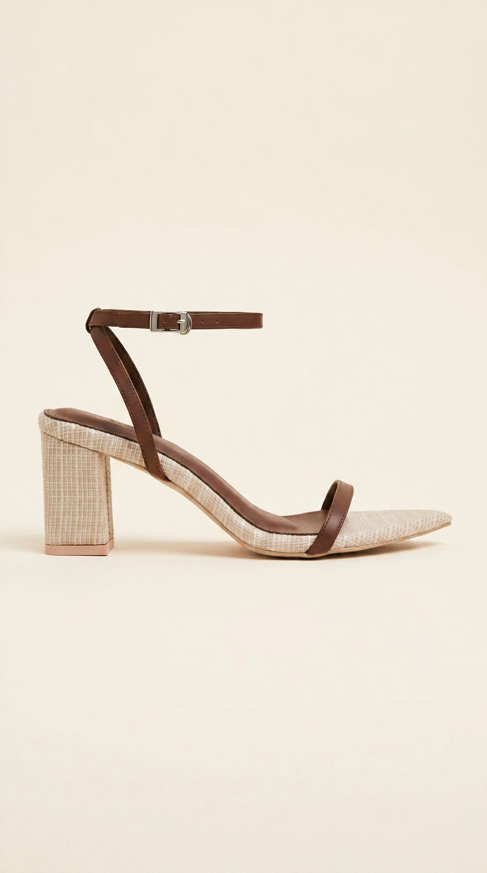 Heeled sandal with brown strap on a beige background