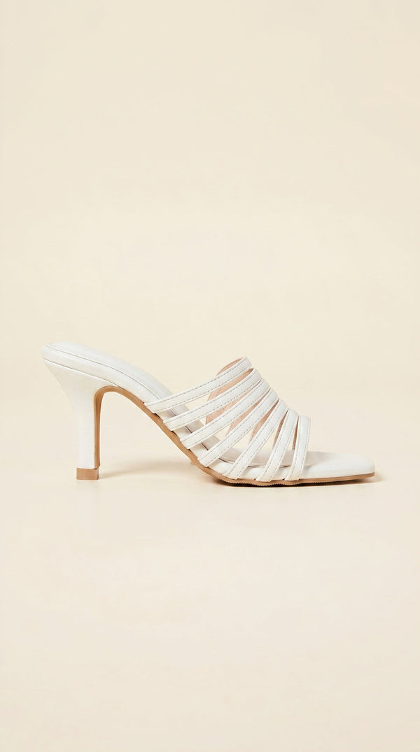 White strappy high-heeled shoe on a beige background