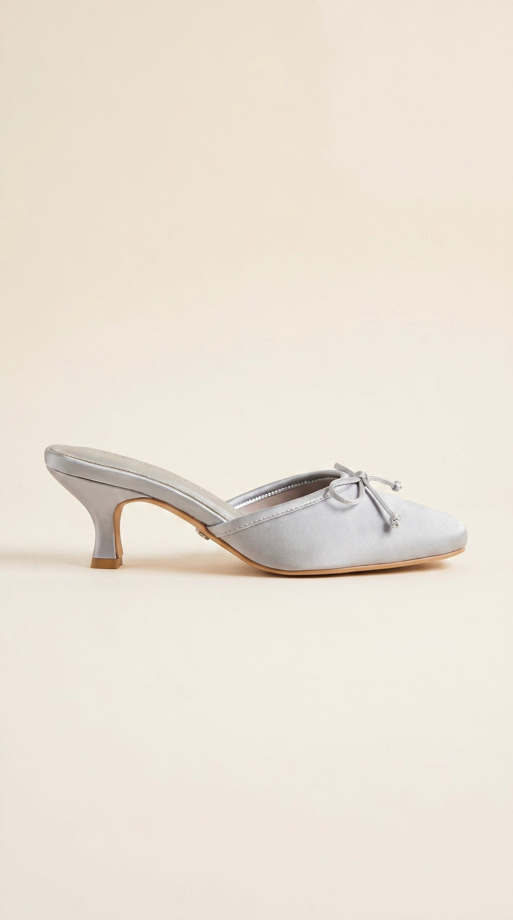 ash blue shoe with a bow on a beige background