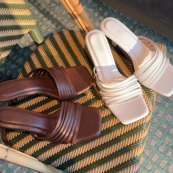 Pair of brown and white sandals on a textured surface