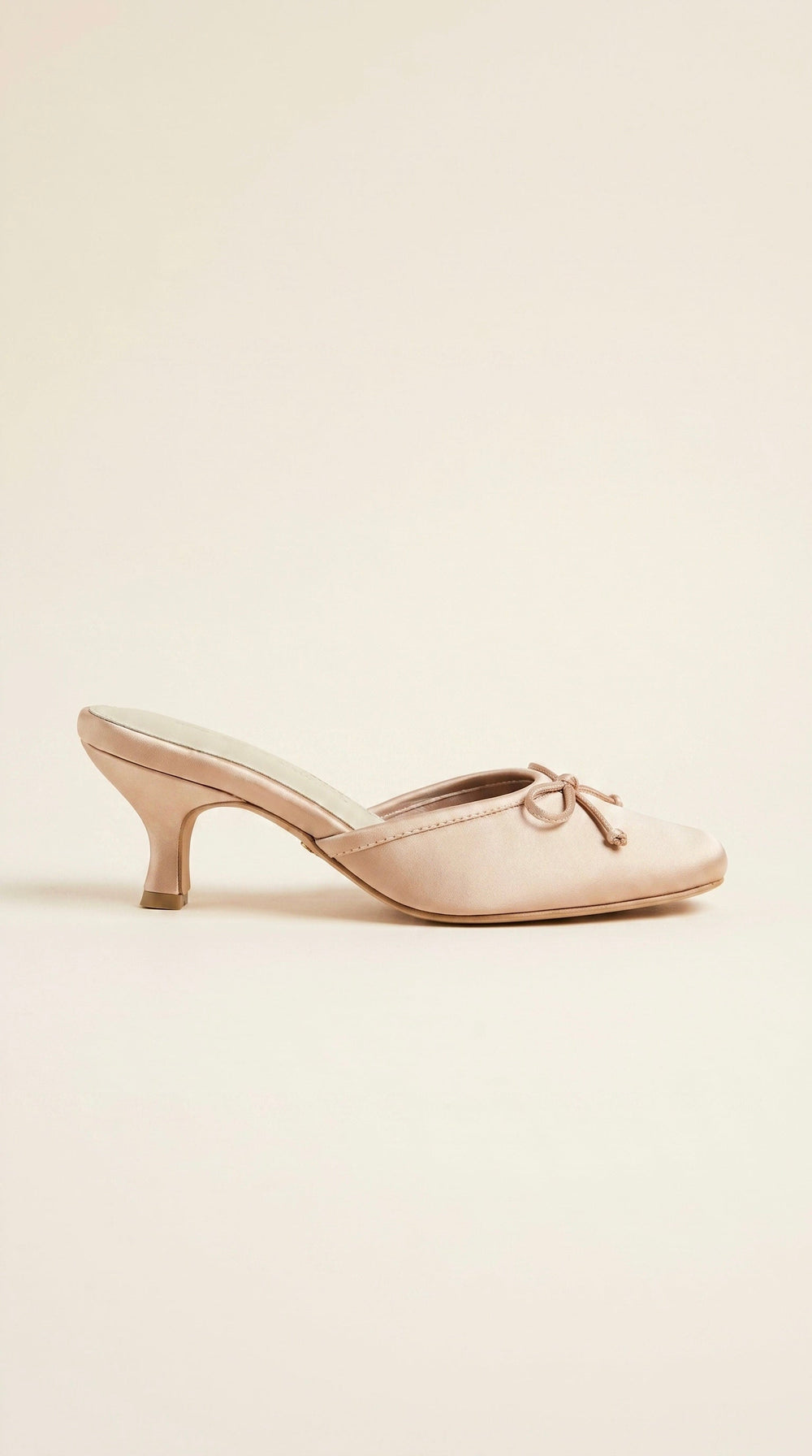 nude shoe with a bow on a light beige background
