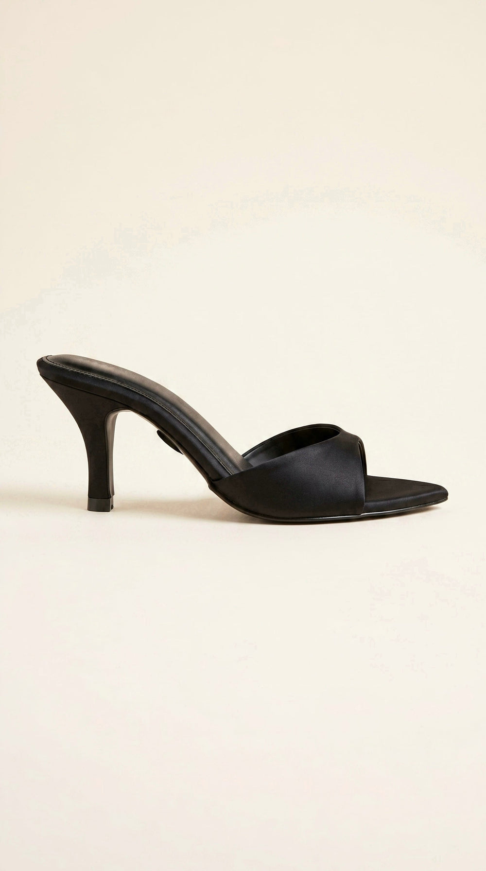 Black high-heeled sandal on a beige background